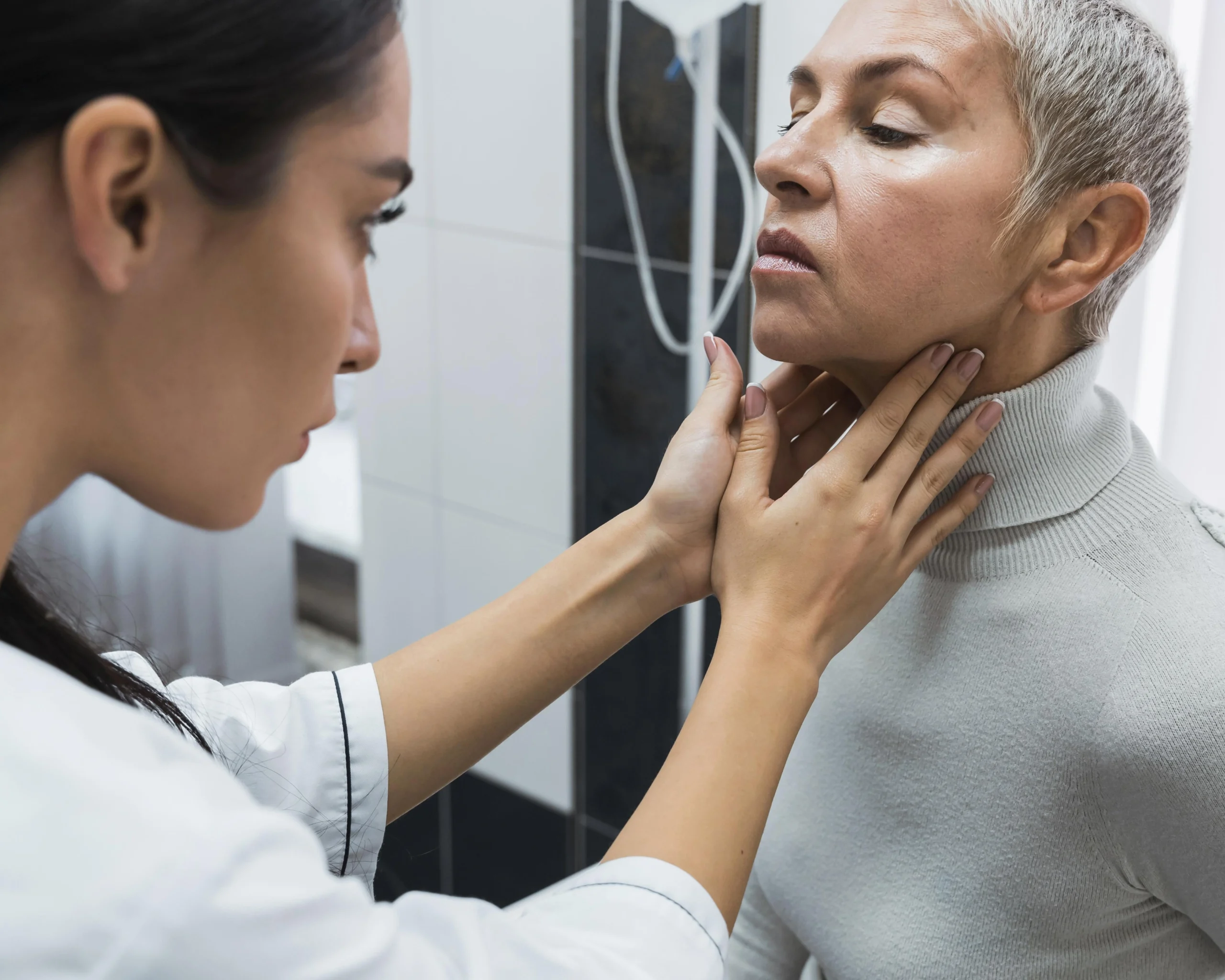 Doctor revisando el cuello de un paciente.