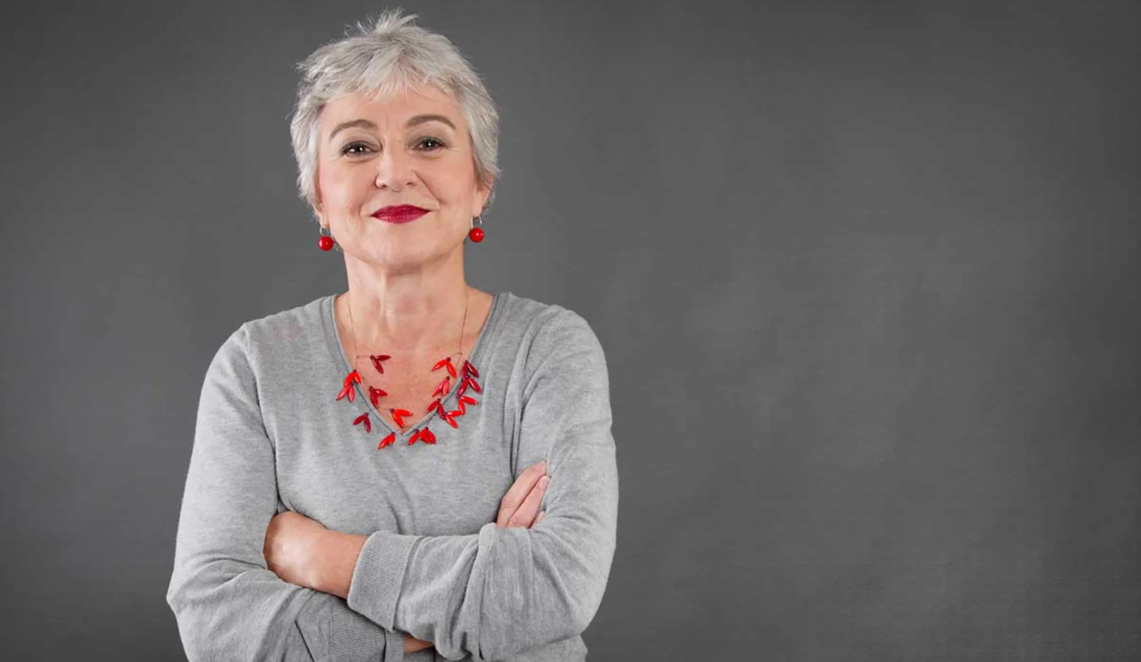 Mujer de la tercera edad con fondo gris.