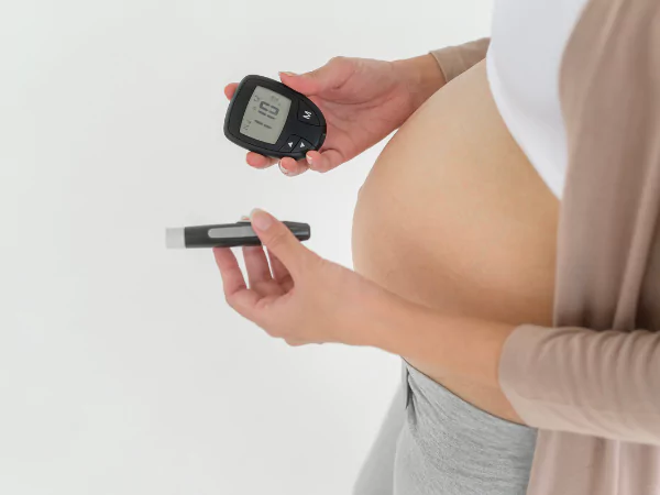 Mujer embarazada controlando su nivel de glucosa con un glucómetro, signo de diabetes gestacional