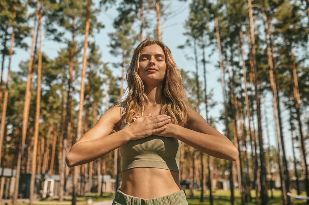 Mujer en paz sobre la naturaleza en espacios de meditación.